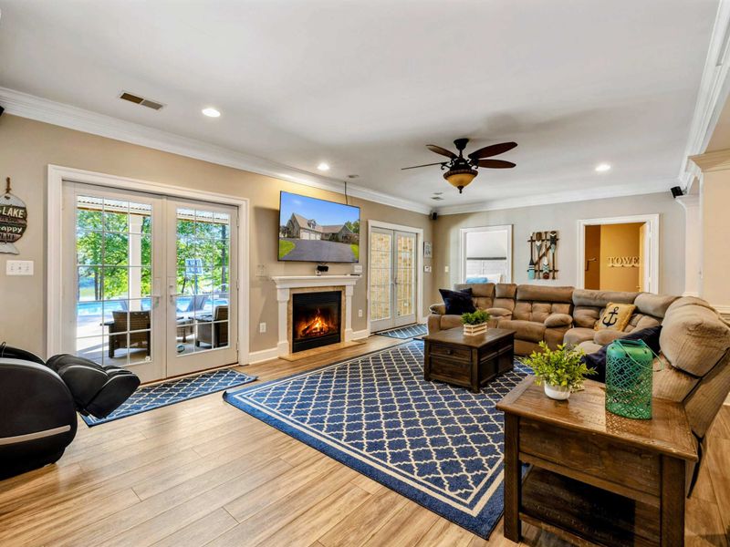 Living Area - French doors to the pool, a massage chair, and the fireplace make this lower-level lounge a flexible gathering spot.