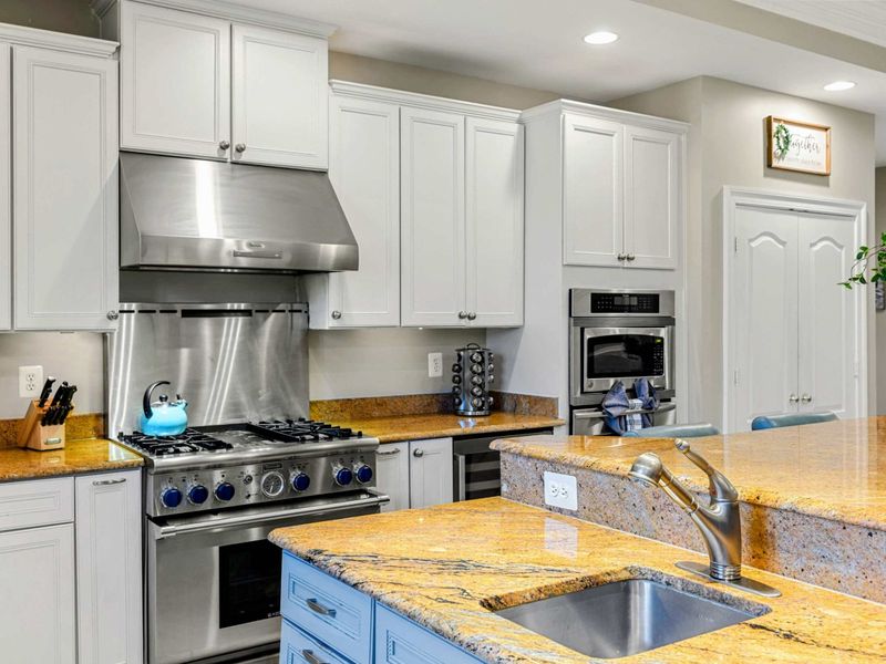 Kitchen - Six-burner gas range, granite countertops, and a built-in wall oven for serious meal prep.