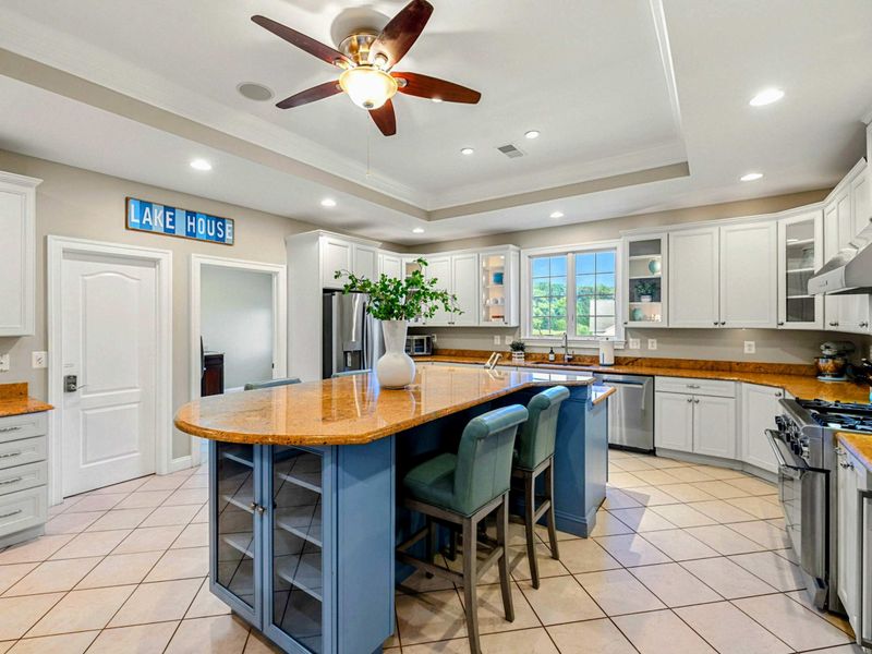 Kitchen - The blue island with built-in wine storage, 'Lake House' sign above, and a walk-in pantry to the left.