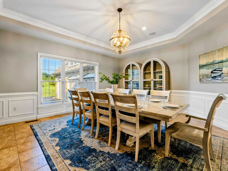 Dining Room - A farmhouse table seats ten under a star-shaped chandelier, with wainscoting and lake-themed art.
