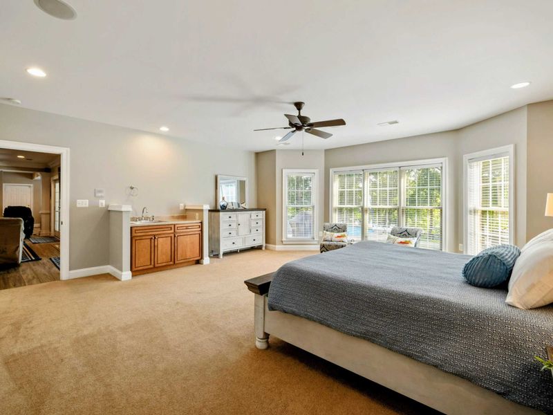 Lake Level Bedroom - A king bed with mini-bar sink, kitchenette view, and ensuite bath visible beyond.