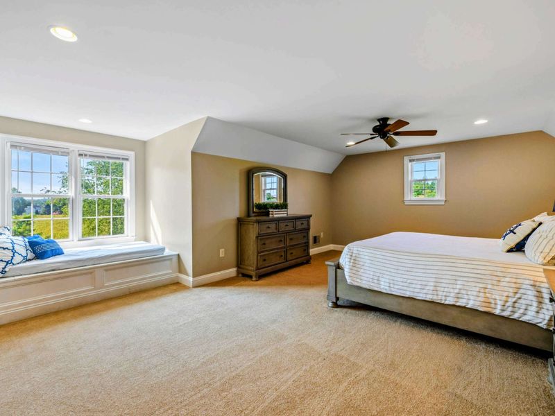 Upper Suite - The second angle shows the dresser, dormer windows, and spacious carpeted floor.