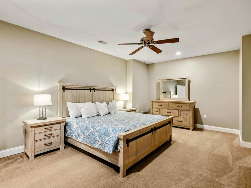 Lake Level Bedroom 2 - A king bed with rustic barn-door headboard, matching nightstands, and dresser.
