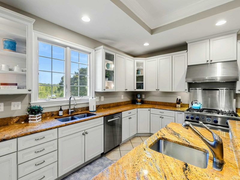 Kitchen - Double sinks, a stainless hood, and open shelving by the window keep everything within reach.