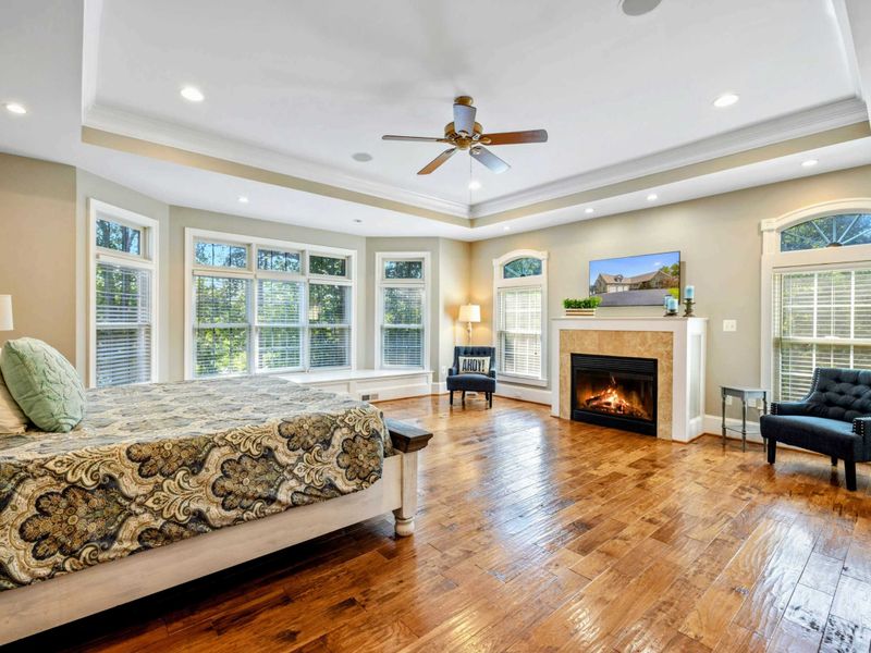 Primary Suite - A king bed, fireplace, and bay windows fill this spacious room with warmth and natural light.