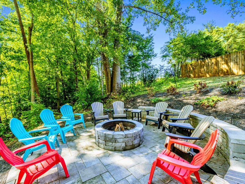 Fire Pit - Gather around the stone fire pit with colorful chairs, tucked into the trees for a cozy evening under the canopy.