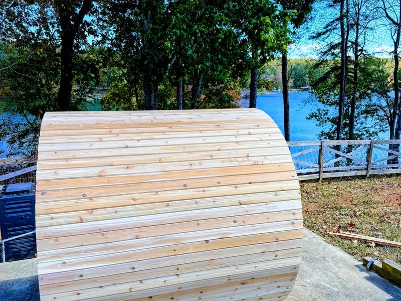 Barrel Sauna - The cedar barrel sauna from behind, with Lake Anna visible through the trees.