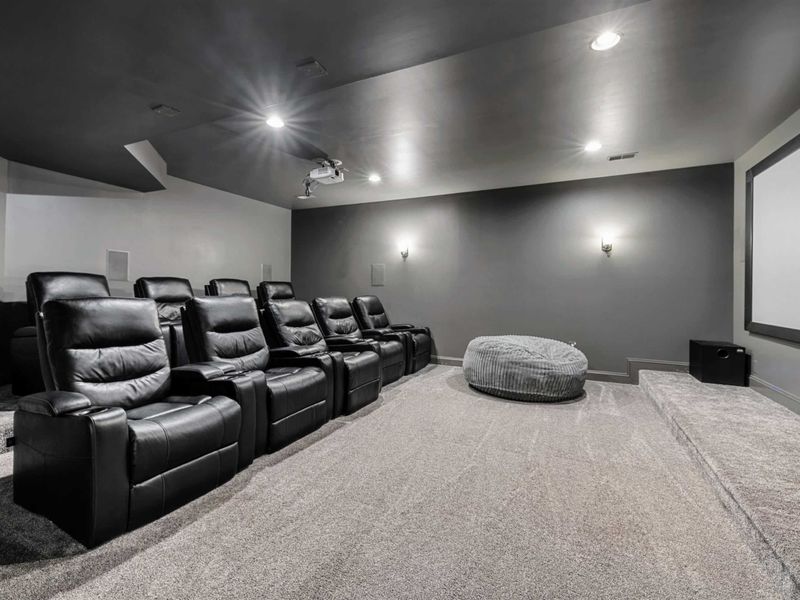 Movie Theater - Two rows of black leather recliners face a projector screen, with a bean bag up front for the youngest movie fans.