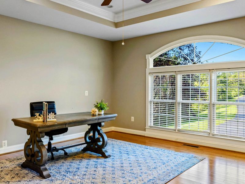 Office - A quiet workspace with an arched window, hardwood floors, and room to spread out.
