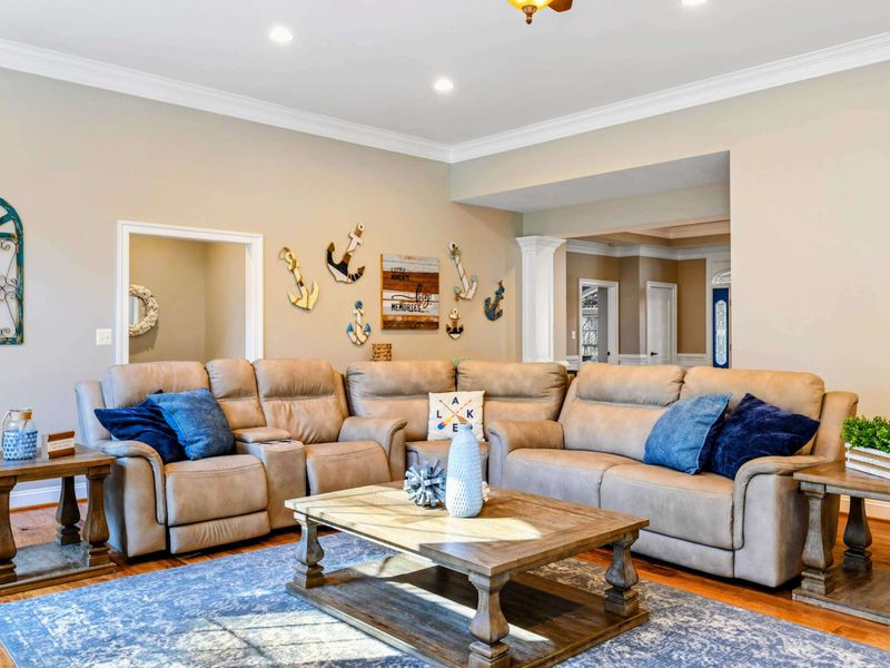 Living Room - Reclining sectional with nautical wall art, connecting to the kitchen and entry hall.