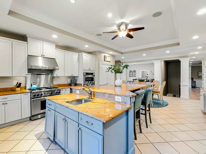 Kitchen - A professional-style range with stainless hood, tray ceiling, and granite island give this kitchen serious cooking power.