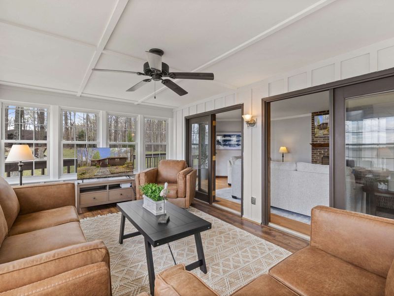 Bright and airy lounge area with elegant leather sofas and sweeping views of the lake through panoramic windows