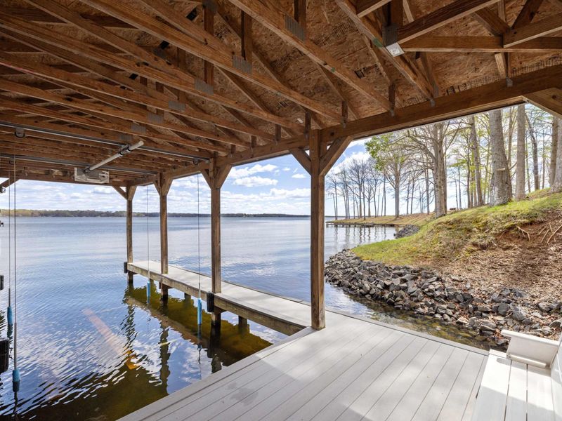 Rustic under-deck view showcasing a peaceful dock and the expansive beauty of the lake beyond