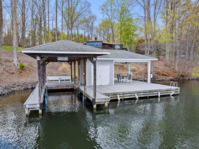 Serene lakeside retreat with a spacious dock and inviting cabin amidst natural surroundings.