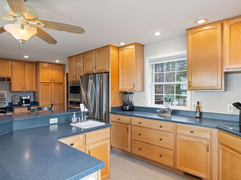 A spacious and well-lit kitchen with modern appliances and wooden cabinetry