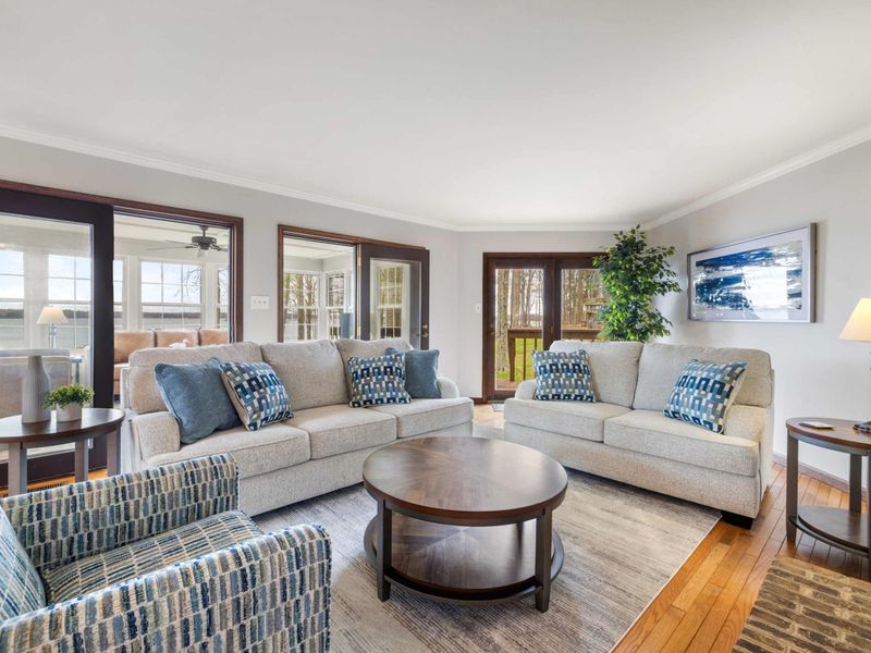 Stylish and comfortable living room with modern decor and large doors opening to a lakeside view
