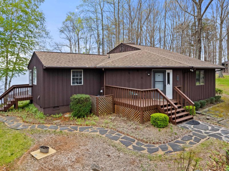 Quaint cabin with a flagstone walkway set in a serene woodland landscape, offering a tranquil retreat.