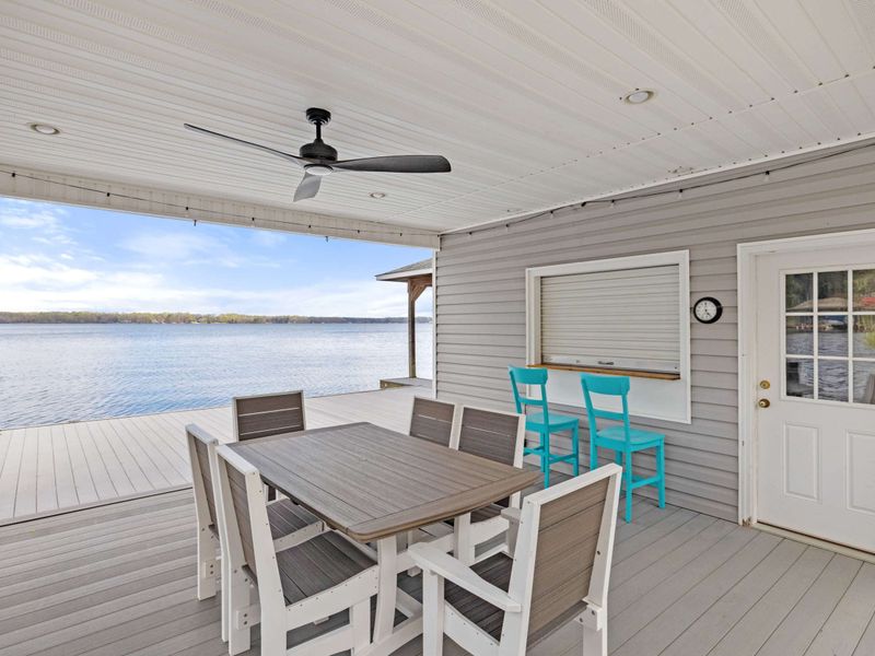 Charming lakeside dining area with a stunning waterfront view, perfect for al fresco meals and relaxation