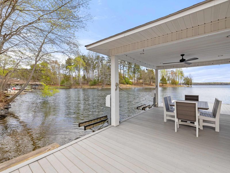 Inviting covered lakefront porch with modern outdoor furniture, perfect for enjoying serene water views