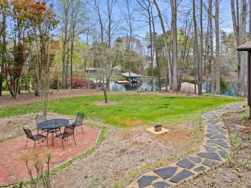 Quaint cabin with a flagstone walkway set in a serene woodland landscape, offering a tranquil retreat.