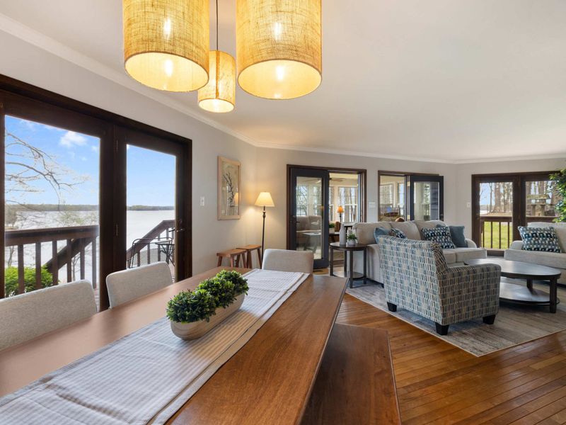 Elegant dining and living area with lake views, modern comforts, and warm lighting, creating a welcoming space for guests