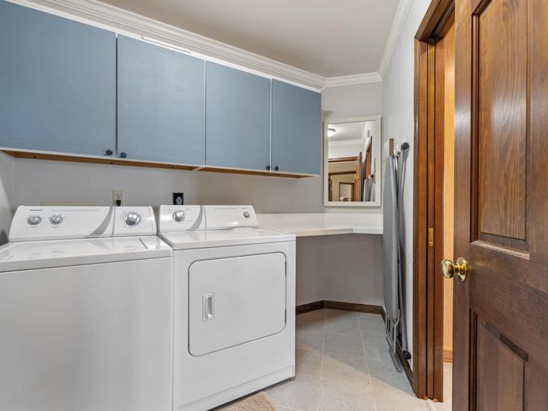 A functional laundry area with a washer, dryer, and storage cabinets