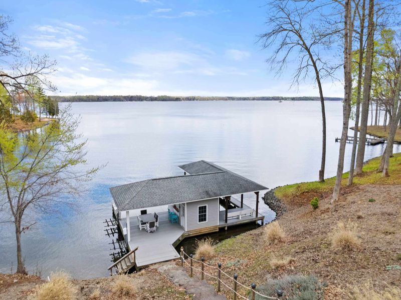 A serene lakeside boathouse with a covered seating area, offering unobstructed views of the peaceful waters and surrounding nature