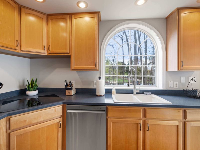 A spacious and well-lit kitchen with modern appliances and wooden cabinetry
