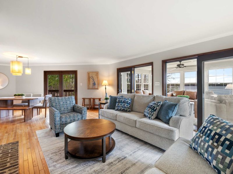 Stylish and comfortable living room with modern decor and large doors opening to a lakeside view