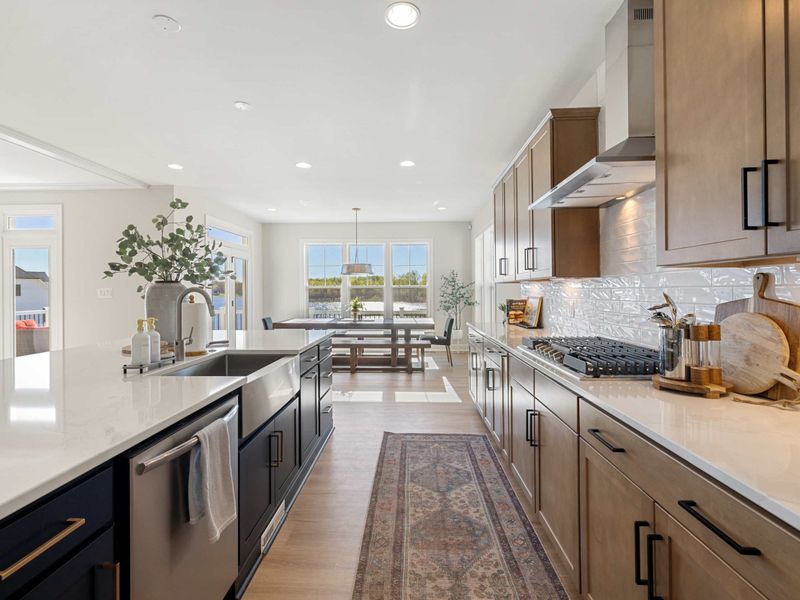Kitchen - A second sweep of the kitchen and its adjacent sitting area, all lit by daylight from the lake-facing windows.