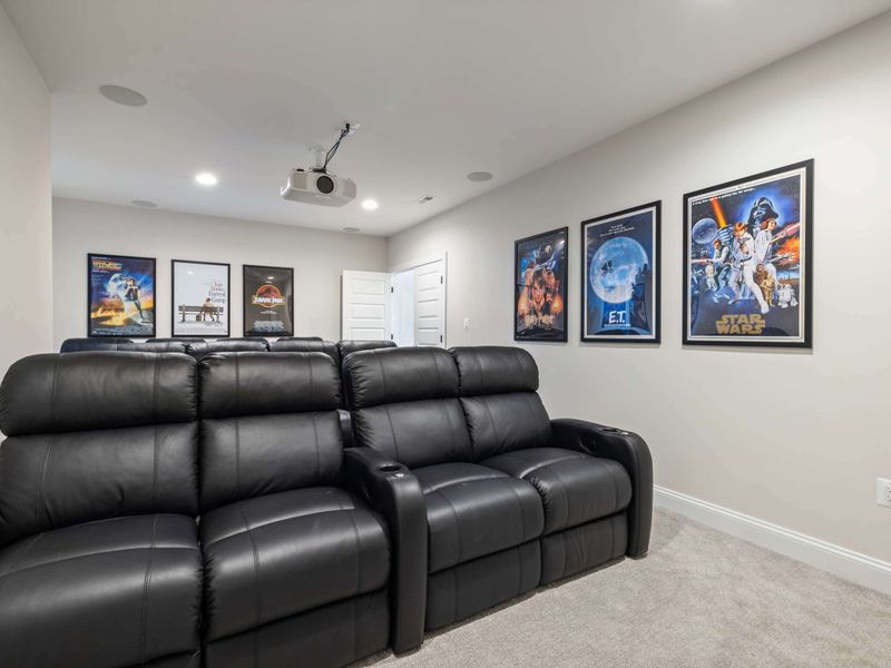 Movie Theater - Framed movie posters, two rows of plush recliners, and a projector overhead for full-on cinema nights.