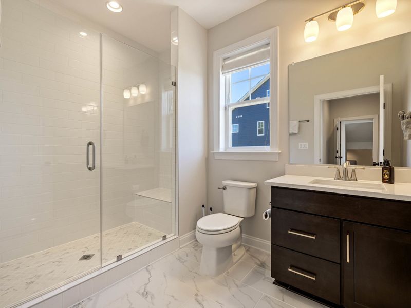 In-Law Suite - Full vanity, storage, and a walk-in shower in the suite's private bathroom.