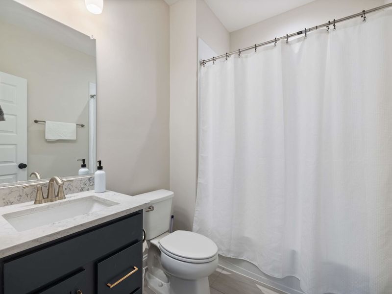 Suite #5 - Suite #5's private bathroom, vanity and shower finished in crisp white for a clean feel.
