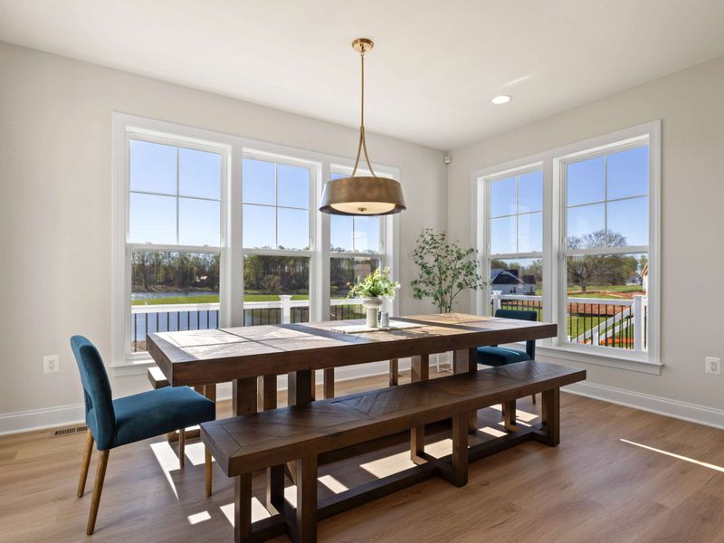 Great Room Dining Area - A wide angle of the great room dining setup, with the whole wall of windows framing the water.