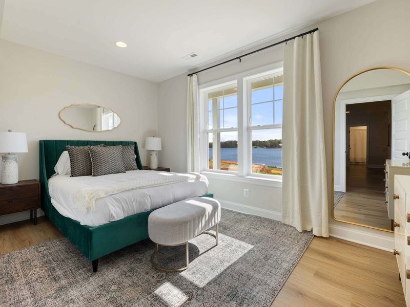 Bedroom 7 - A queen with a deep green velvet headboard, modern lines, and a peek at the lake through the side window.