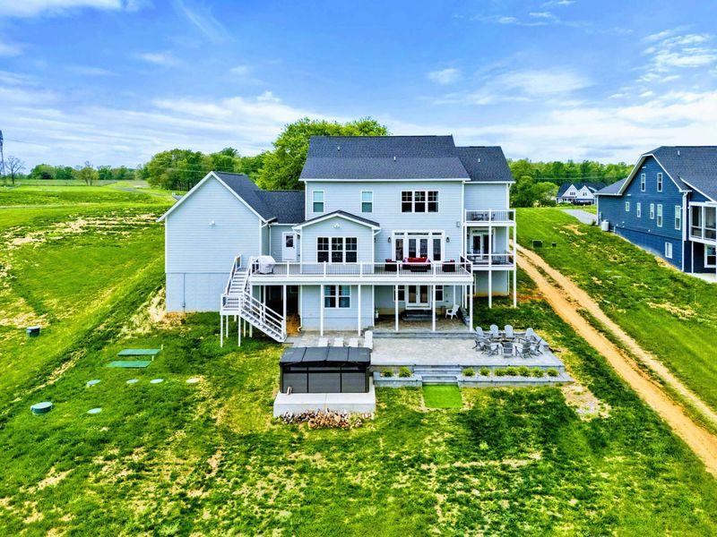 Backyard - Aerial of the house, swim spa, and patio all open to the lake view beyond.