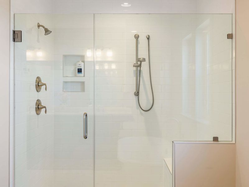 Primary Suite - Glass-walled walk-in shower with a clean tile finish, the kind of bath you don't want to leave.