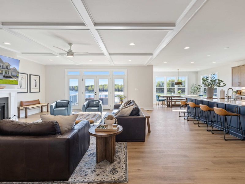 Great Room - Coffered ceilings, a sectional sofa, and a wall of windows that pull the lake view right into the heart of the house.