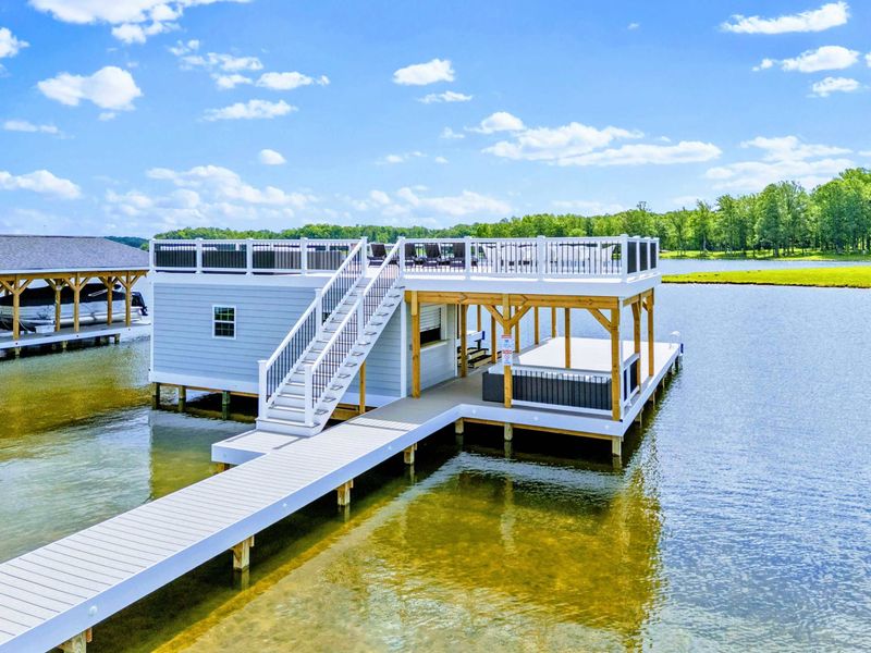 Backyard - The dock spread in full daylight, boat slips on one level and a rooftop lounge stacked above.