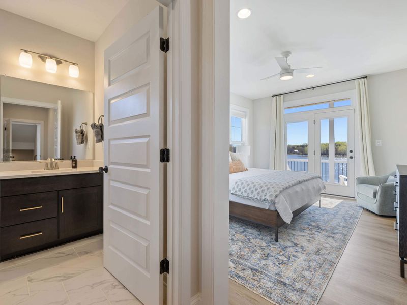 In-Law Suite - Looking back through the ensuite toward the bedroom, a wide mirror doubling the daylight.