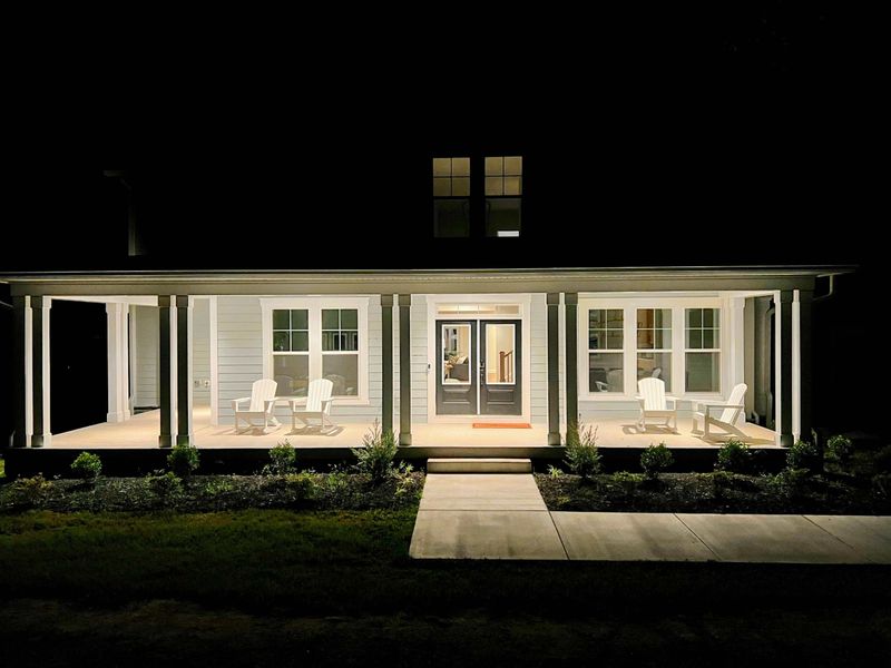 Exterior - The home lit up at night, porch lights glowing and the patio waiting for the evening wind-down.