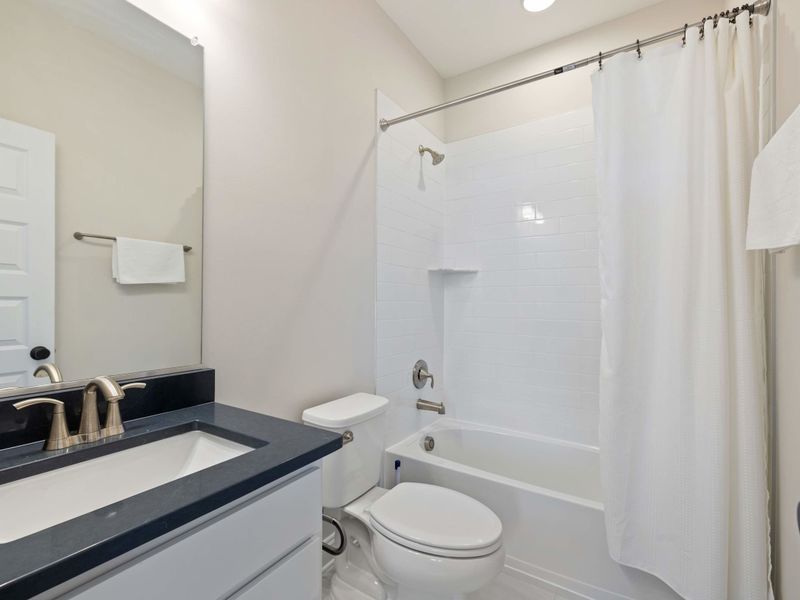 Suite #4 - The suite's ensuite bathroom with a tub-shower combo, vanity, and good natural light.