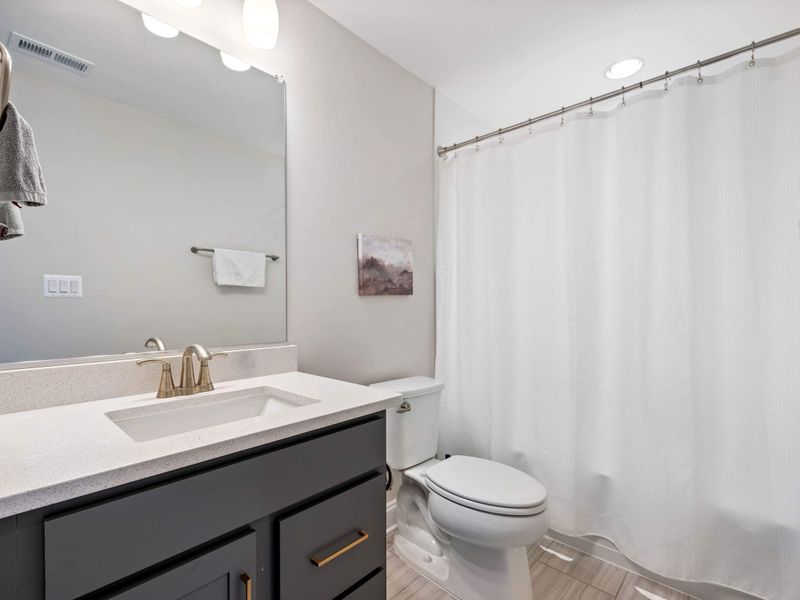 Full Bathroom - A clean shared bath with quartz vanity, tub-shower combo, and neutral finishes throughout.