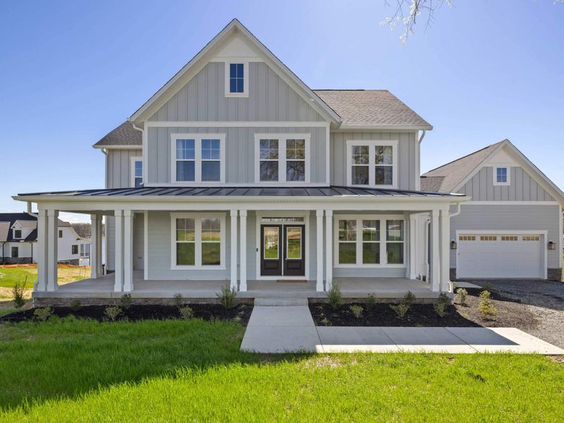 Exterior - Wide shot from the front yard, the house and its clean lines anchored by green lawn and open sky.