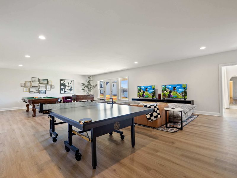 Game Room - The long view of the game room, arcade machines, lounge seating, and soft bean bags for between-match hangs.