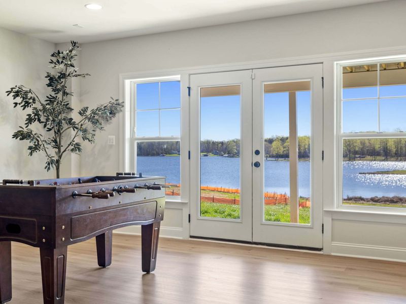 Game Room - Foosball table positioned near the sliding doors, lake views keeping the competition light.