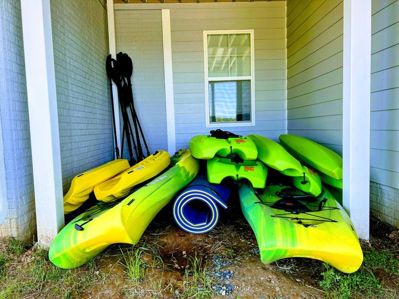 Backyard - Yellow kayaks stacked on the lawn, ready for whoever wants to push off first.