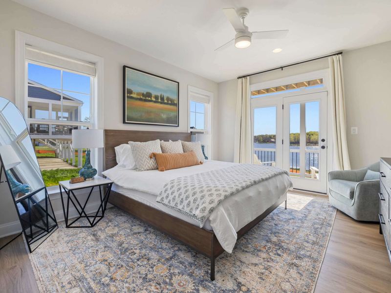 In-Law Suite - A sunny king bedroom with a private deck view and soft neutral finishes throughout.