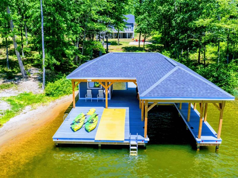 Lakeside boathouse with kayaks and a swim platform, perfect for water activities and relaxation