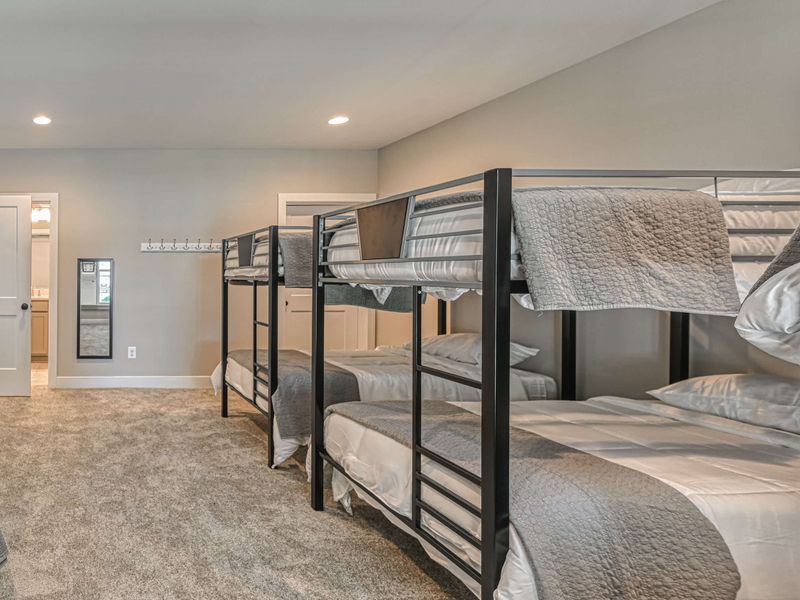 Spacious bunk room with multiple beds, perfect for accommodating large groups or families